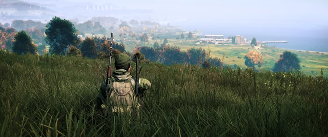 DayZ screenshot player sitting down in the grass.